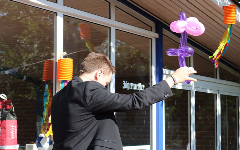 Thomas Majka mit einer Luftballonblume in der Hand bei einer Kinder-Zaubershow