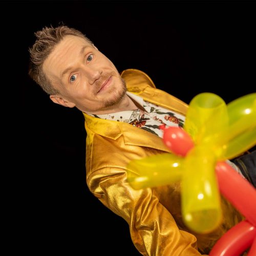 Thomas Majka hält eine bunte Luftballonblume in der Hand